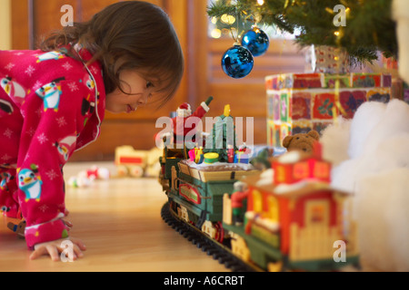 Bambina guardando Toy Train Foto Stock