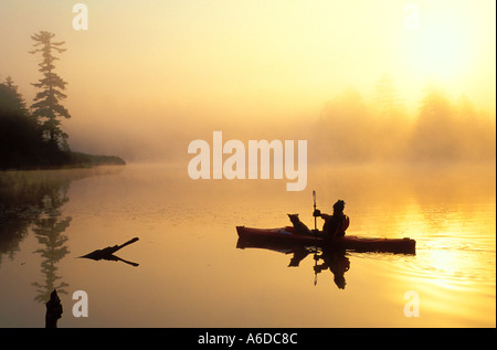 Kayaker e un cane sul lago scheggiature nel Adirondacks dello Stato di New York Foto Stock