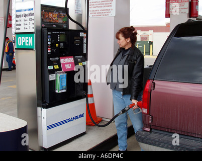 Donna riempimento di grandi Chevy Suburban SUV con benzina Foto Stock