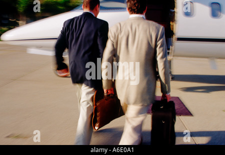 Due dirigenti maschi in movimento a piedi verso il jet privato Foto Stock