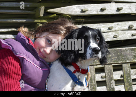 Ragazza giovane con il suo cucciolo English Springer Spaniel coccole Foto Stock