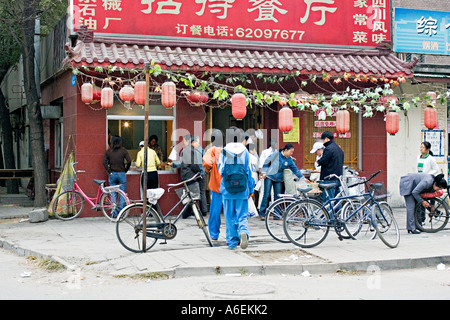 Cina Pechino minuscolo ma occupato quartiere ristorante con chef impostato sul marciapiede per preparare la colazione gnocchi di uova sode Foto Stock