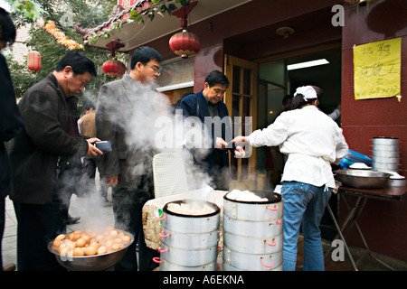 Cina Pechino cinese uomini business line fino al piccolo ma affollato quartiere ristorante Foto Stock