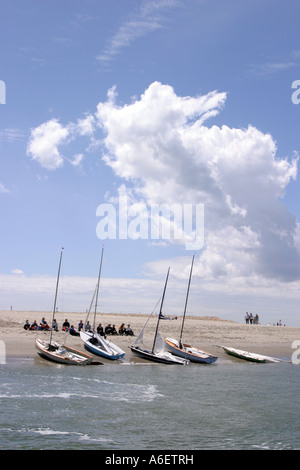 Yacht ormeggiati sulla spiaggia e la gente seduta sulla sabbia, testata est, Chichester, West Sussex, Regno Unito Foto Stock