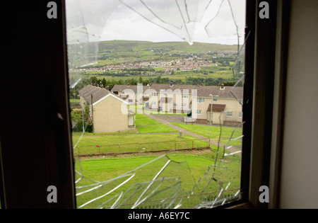 Vista attraverso il vetro fracassato di vuoto casa abbandonati sulla Gurnos Station Wagon Merthyr Tydfil South Wales UK Foto Stock