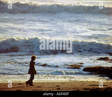 Pensieroso giovane donna da sola sulla spiaggia Foto Stock
