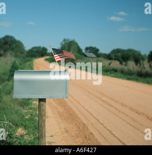 Mailbox con piccola bandiera degli Stati Uniti sul paese strada di argilla Foto Stock