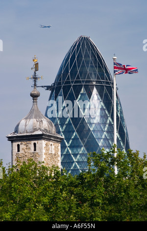 La Swiss Re Tower, la Torre di Londra, l'Unione Jack & un jet del passeggero Foto Stock