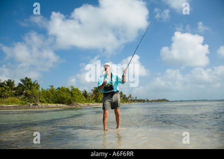 BELIZE Ambergris Caye maschi adulti per la pesca con la mosca in appartamenti lungo il litorale per bonefish wading boots canna da mosca e attrezzature Foto Stock