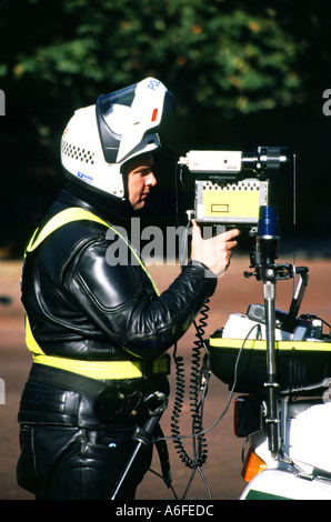 Agente di polizia di Royal Parks al lavoro che opera con telecamera di controllo velocità 1998 dal retro della sua moto parcheggiata in The Mall Road Londra Inghilterra Regno Unito Foto Stock