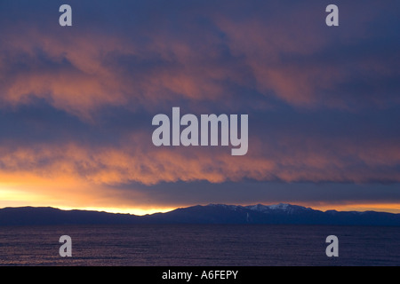 Alpenglow sulle nuvole sopra il lago Tahoe e riflessioni all'alba Foto Stock