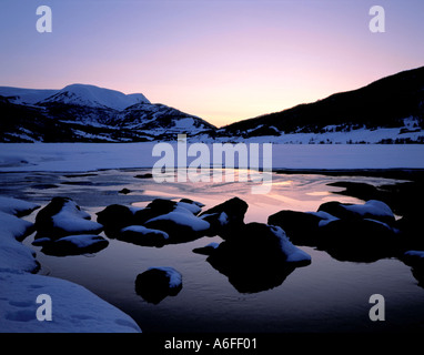 Sun al di sotto dell'orizzonte visto oltre Møkkelandsvannet in inverno, Ervik, vicino a Harstad, Hinnøya, Troms, arctic Norvegia. Foto Stock