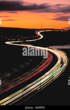 Sentieri di luce sull'autostrada M62 di notte nei pressi di Moss Moor, Yorkshire, Inghilterra, Regno Unito. Foto Stock