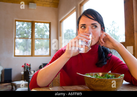Giovane donna a casa mangiare sano insalata verde Foto Stock