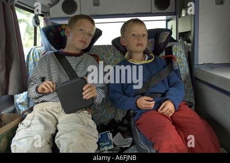 Due stanchi di sei e otto anni i ragazzi sul retro di una VW camping car Foto Stock