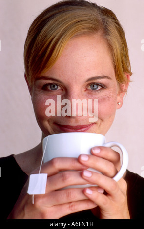 Donna gustando una tazza di tè caldo Foto Stock