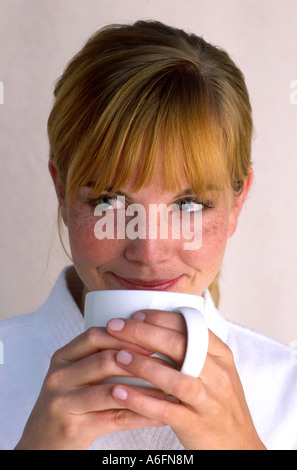 Donna sorseggiate una tazza bianca Foto Stock