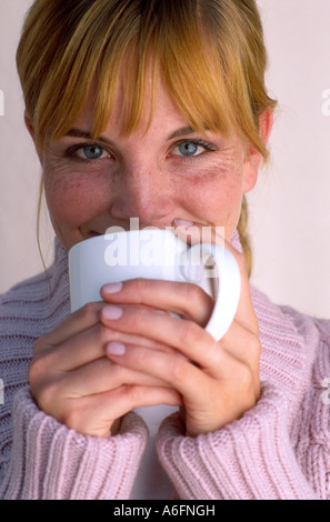 Donna sorseggiate una tazza bianca Foto Stock