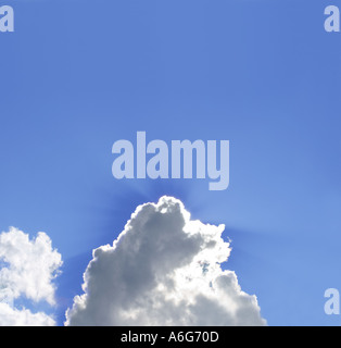 Sun nascoste dietro le nuvole nel cielo blu Foto Stock