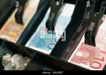 Cassa piena di monete e banconote in euro Foto Stock