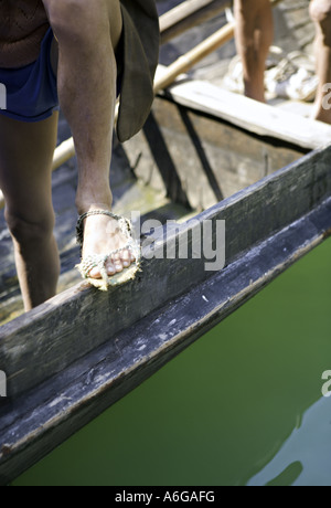 Cina fiume Yangtze forti muscoli e sinewy gambe di un barcaiolo peapod con sandali fatta di corda locale Foto Stock