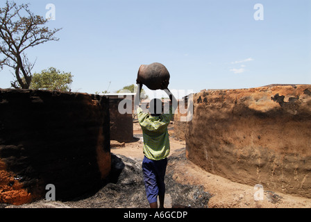 Per il campo per sfollati dal conflitto istigata da parte del Lord s Resistance Army salvataggio beni di base dopo un incendio Foto Stock