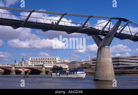 Millennium Bridge (architetto: Norman Foster & Partners; 2000) oltre il Fiume Tamigi, con tour in barca a Londra, Inghilterra Foto Stock