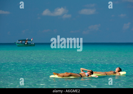 Due giovane donna in bikini galleggiante sul giallo materassi aria Perhentian Kecil Malaysia Foto Stock