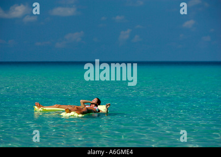 Due giovane donna in bikini solo flottante su giallo materassini Perhentian Kecil Malaysia Foto Stock