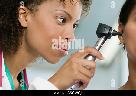 Esame medico paziente con otoscopio Foto Stock