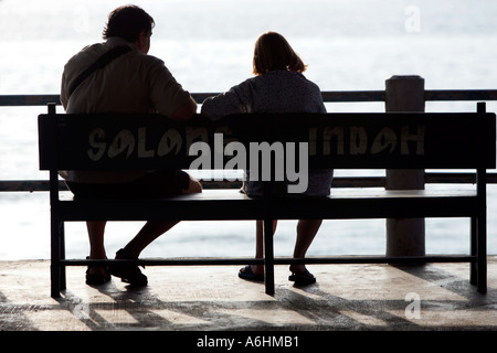 Paio di sedersi alla fine del molo Salang Beach Isola di Tioman Malesia Foto Stock