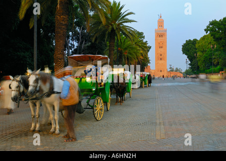 Carrozza a cavallo e driver con Minareto di Koutoubia in background, Marrakech, Marocco, Africa Foto Stock