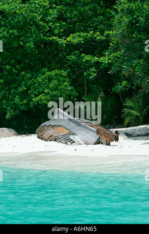 Chiglia e nervature di capovolta la barca abbandonata sulla spiaggia Perhentian Besar Malaysia Foto Stock