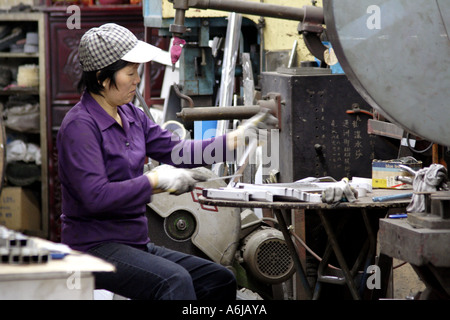 Hong Kong SAR, Cina, donna che lavorano presso un negozio di macchina a Kowloon Foto Stock