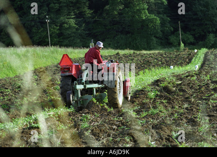 Coltivatore su un trattore arare il suo campo, Mlodowice, Polonia Foto Stock