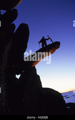 Sciatore in piedi su un Hanging Rock al tramonto a Thredbo, Australia Foto Stock