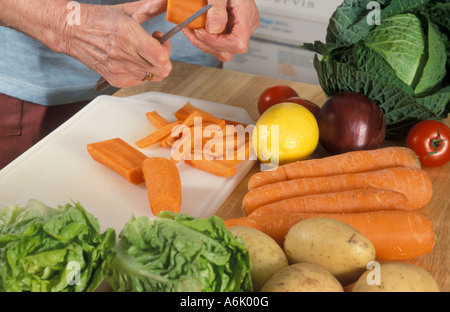 Close up donna matura le mani peeling ortaggi sani Foto Stock