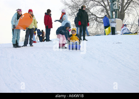 La sommità della collina di bambini sempre pronti a slitta verso il basso in Lincoln Park di Chicago IL Foto Stock