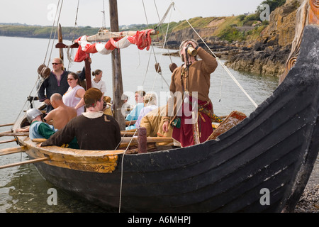 AMLWCH BIENNALE VIKING FESTIVAL attori in legno barca lunga lasciando dopo la battaglia rievocazione Isola di Anglesey North Wales UK Foto Stock