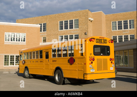 Scuola bus parcheggiato di fronte alla scuola superiore Foto Stock