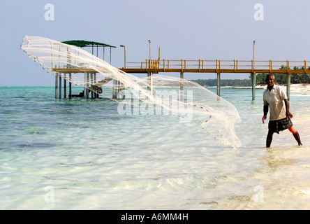 Pescatore locale getta la sua rete sulla isola di Agatti in Lakshadweeps, India Foto Stock