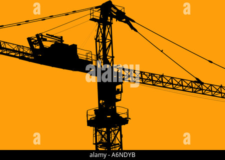 Una grande gru di sollevamento in corrispondenza di un sito di costruzione contro un cielo arancione Foto Stock