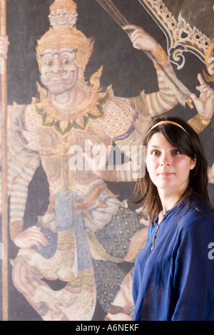 Turisti occidentali che pongono di fronte a un murale in Grand Palace Foto Stock