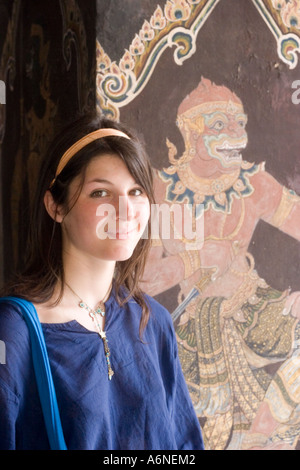 Backpacker femmina che pongono di fronte a un murale in Grand Palace Foto Stock