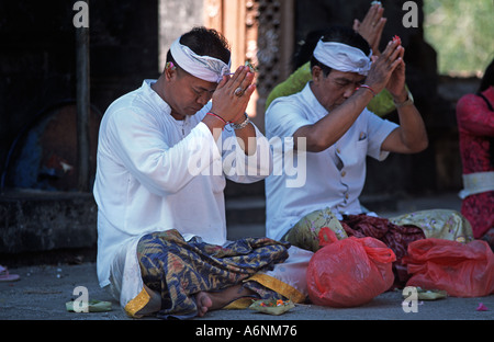 Gli uomini di pregare alla cerimonia Indù Pulaki tempio di Bali s N costa è un importante luogo di pellegrinaggio in Indonesia Foto Stock