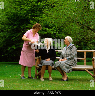 Casa di riposo anziani vengono serviti tè in giardino Foto Stock
