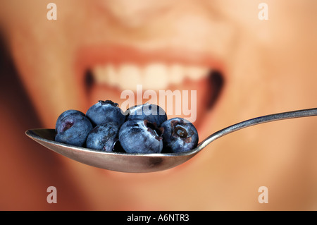 Donna di mangiare la frutta di mirtilli Foto Stock