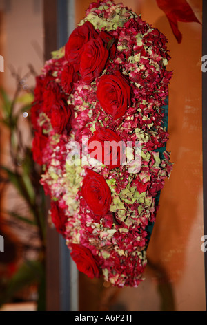 A forma di cuore ad corona di rose rosse sulla porta Foto Stock