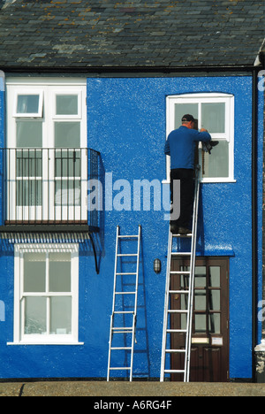 L uomo sulla scala lavorando sul primo piano finestra proprietà domestica Foto Stock