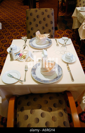 Sala da pranzo con tavoli preparati a bordo della nave da crociera Foto Stock